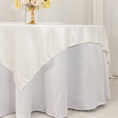 Elegant white tablecloth draped over a round table in a soft setting.