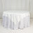 White round table with a smooth tablecloth draping to the floor.