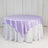 Round table covered with a lilac satin tablecloth.
