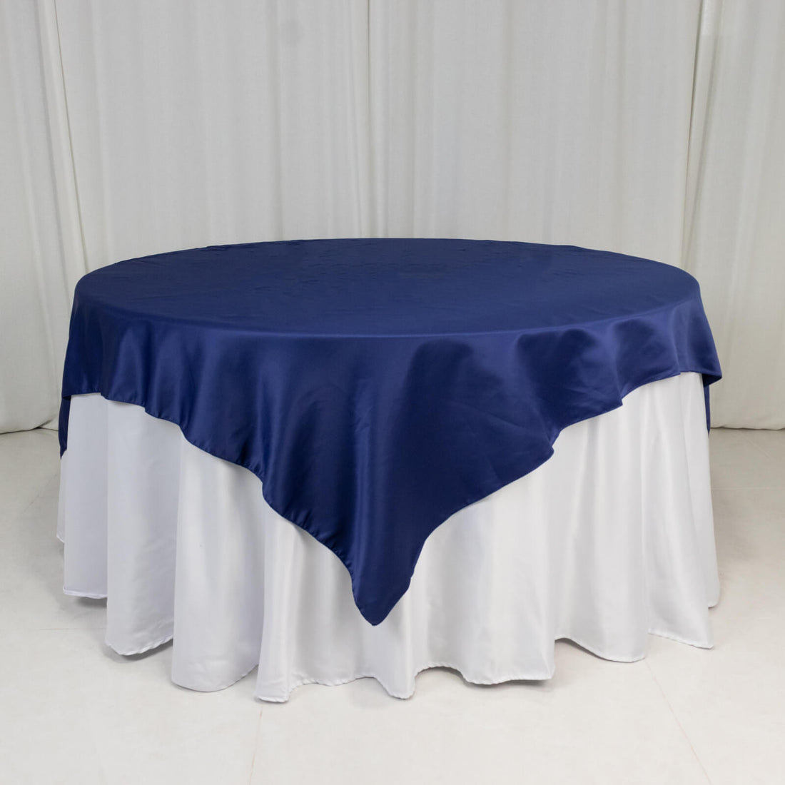 Round navy tablecloth draped over a white table.