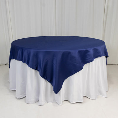 Round navy tablecloth draped over a white table.