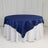 Round navy tablecloth draped over a white table.