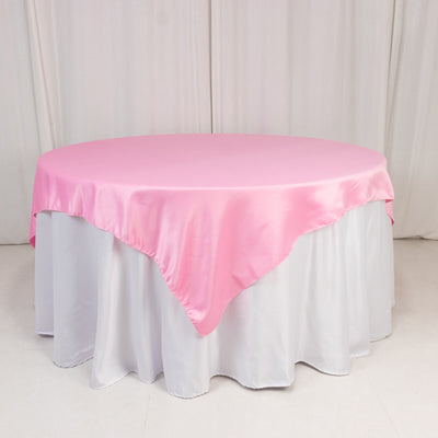 Pink satin tablecloth draped over a round table.