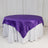 Round table with a purple satin tablecloth and white skirt.