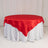 Round table with red satin tablecloth and white skirt
