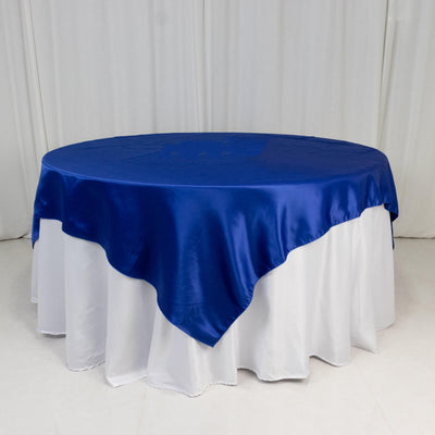 Round blue satin tablecloth draped over a white table.