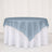 Blue sheer table overlay on round white tablecloth for elegant event décor