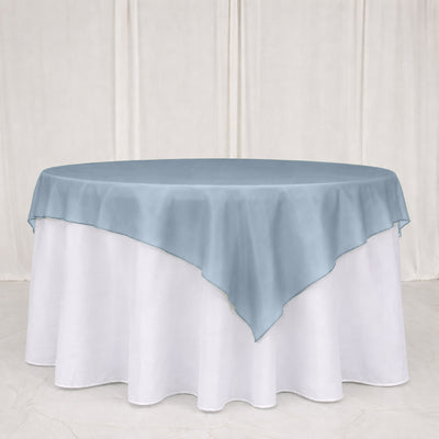 Round table with light blue overlay and white floor-length tablecloth