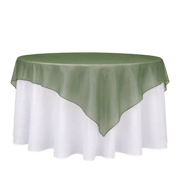Round table with sage green overlay and white tablecloth