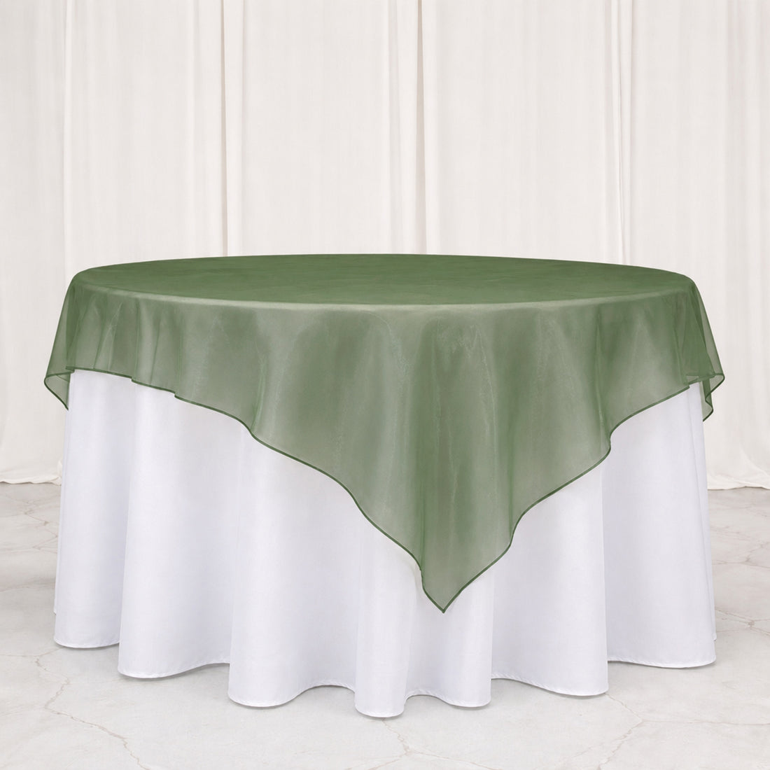 Green sheer overlay round tablecloth on white banquet table