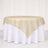 Elegant round tablecloth with a gold satin overlay on a white table.