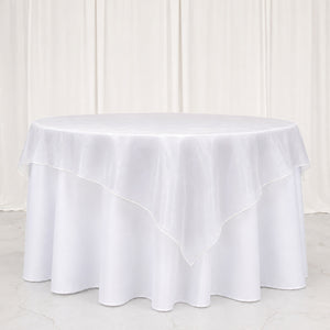 White round tablecloth with elegant layered overlay on a round table