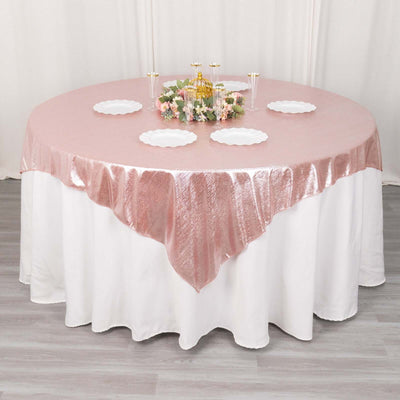 Pink sequin tablecloth on a round table set for an elegant dining experience.