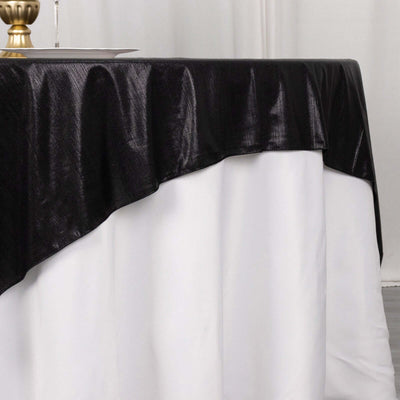 Black tablecloth draped over a white table, showcasing elegant texture and draping.