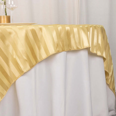 Gold striped tablecloth draping over a white table.