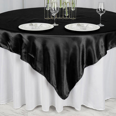 Black satin tablecloth draped elegantly over a white table setting.