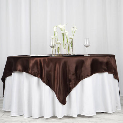 Elegant brown tablecloth draped over a white table, styled with glassware and flowers.
