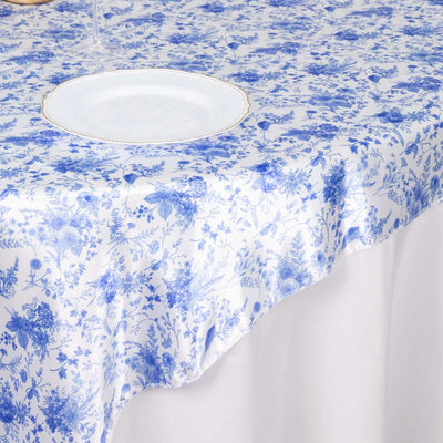Blue floral tablecloth on a white table setting.