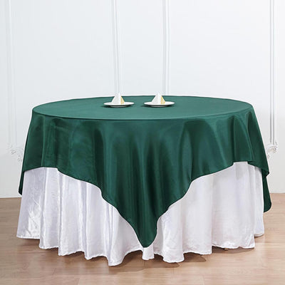 Green round tablecloth draped elegantly over a white table.