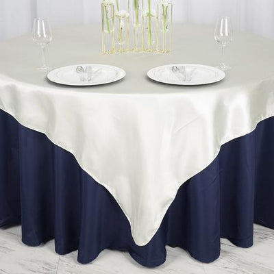 Elegant table setting with satin tablecloth and glassware.
