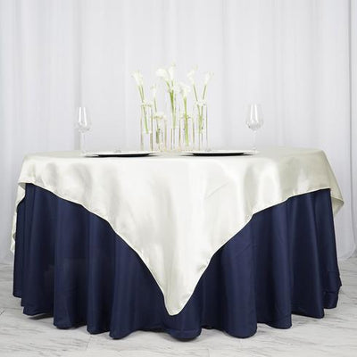 Elegant table setting with a cream and navy tablecloth and flower centerpiece