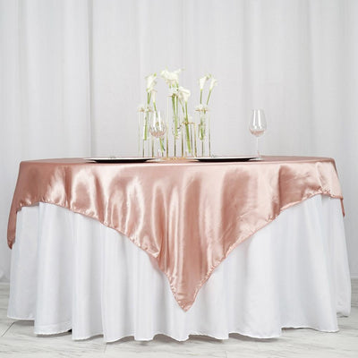 Rose gold satin tablecloth draped elegantly over a white table.