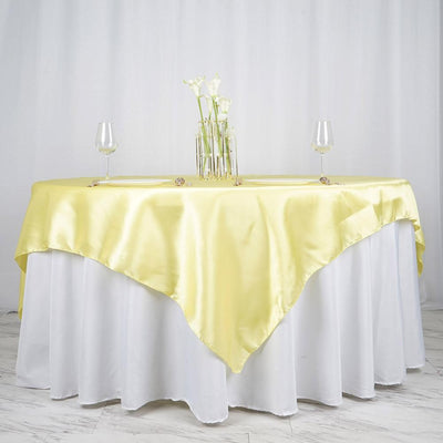 Yellow satin tablecloth draped elegantly over a white table.