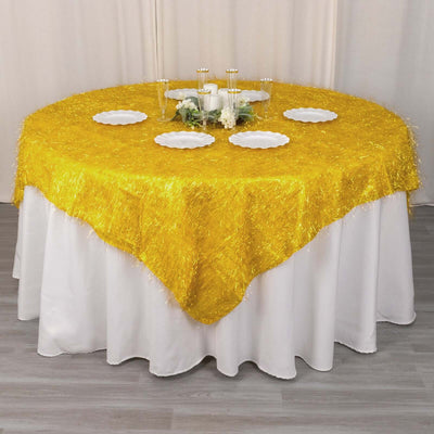 Yellow fringed tablecloth draped over a round table with white plates.