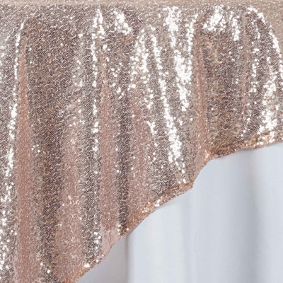 Rose gold sequin tablecloth with shimmering texture.