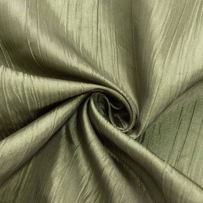 Textured green fabric with a soft sheen in a swirling pattern.