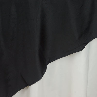 Black satin fabric draped over a white surface, showcasing its smooth texture.
