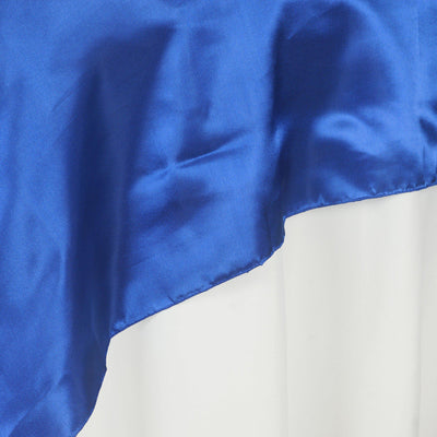 Blue satin fabric draped elegantly on a white surface.