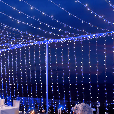 String lights illuminating a night sky at an outdoor event.