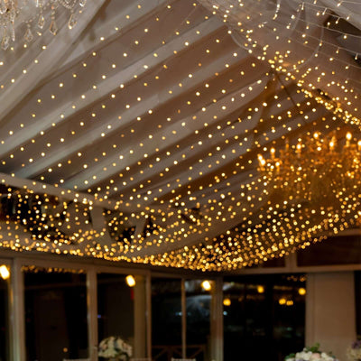 Elegant string lights illuminating a wedding venue ceiling.