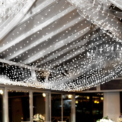 Twinkling fairy lights draped across a ceiling in a beautifully decorated venue.
