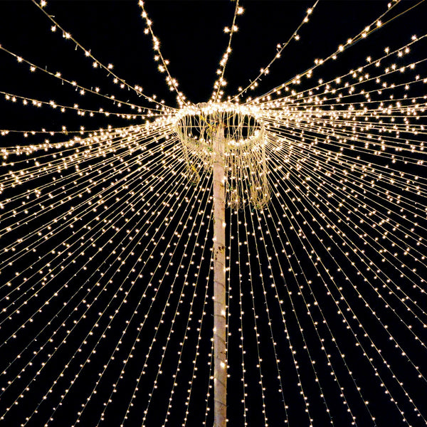 String lights radiating from a central pole against a dark background.