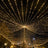Illuminated string lights creating a starburst effect in a night scene.