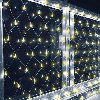 Fairy lights in a decorative net design, illuminating a dark window.