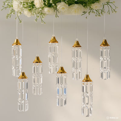 Hanging crystal chandeliers with gold accents against a soft background.
