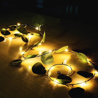 String lights with green leaves, creating a warm ambiance.