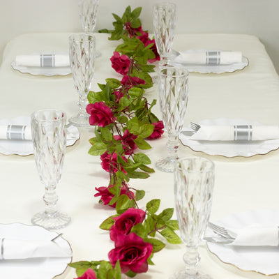 Elegant table setting with crystal glasses and rose floral centerpiece.