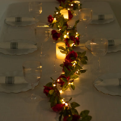 Elegant table setting with roses and candles, perfect for intimate dining occasions.