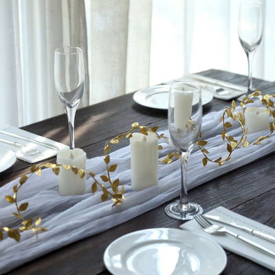 Elegant table setting with candles and golden leaf decor.