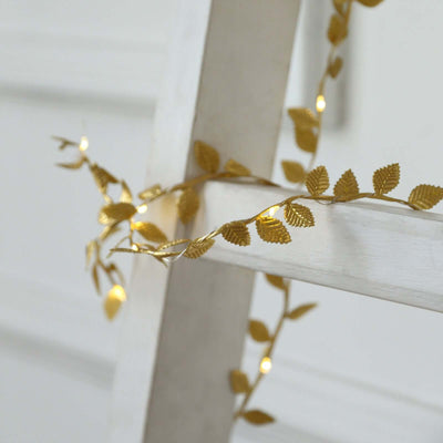 Gold leaf fairy lights on a white ladder