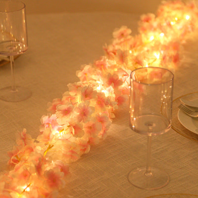 Pink flower garland with lights on a table setting