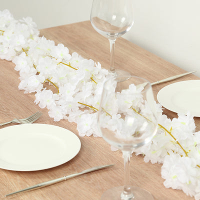 Elegant white floral table centerpiece with wine glasses and plates.