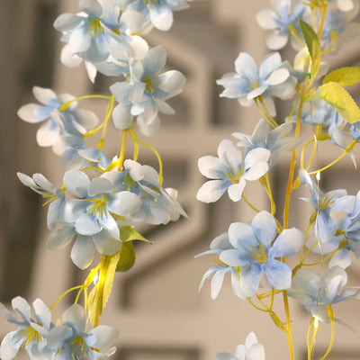 Blue artificial flower garland on a neutral background.
