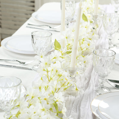 Elegant dining table set with white flowers and candles, perfect for a special occasion.