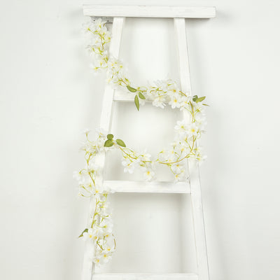 White flower garland draped on a white ladder
