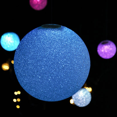 Glowing blue decorative orb with sparkles against a dark background.